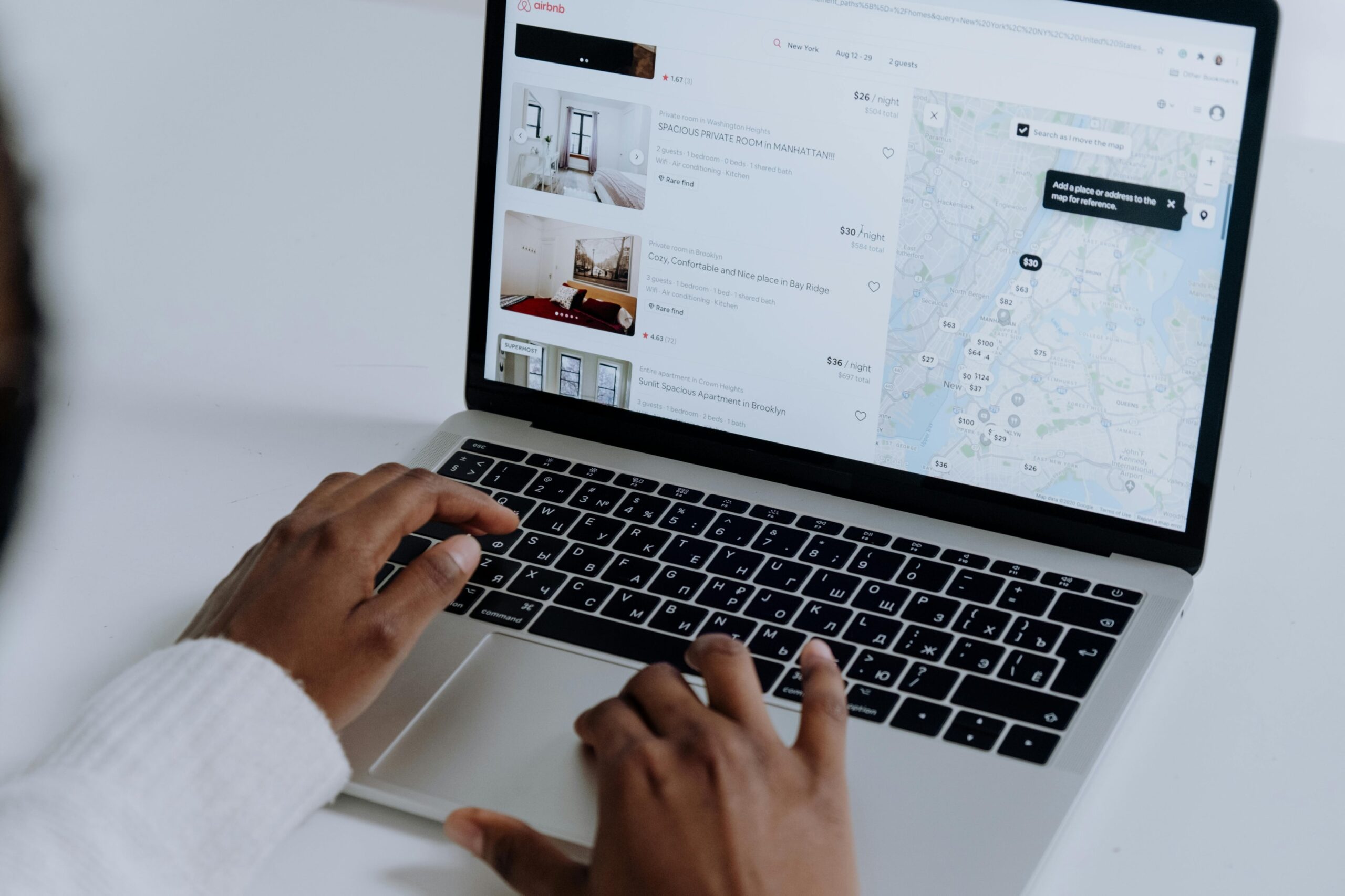 A picture of a lady about to book a hotel via her laptop