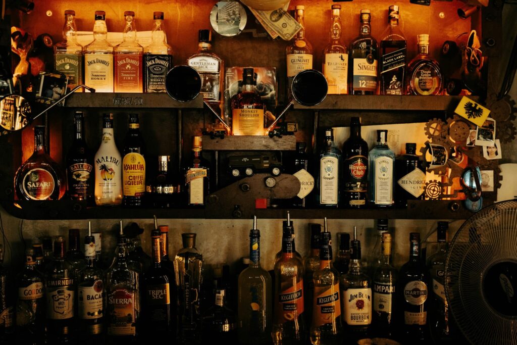 A picture of exotic bourbon bottled and branded drinks on a bar shelf opposite hotels considered to be top-tier in Kentucky