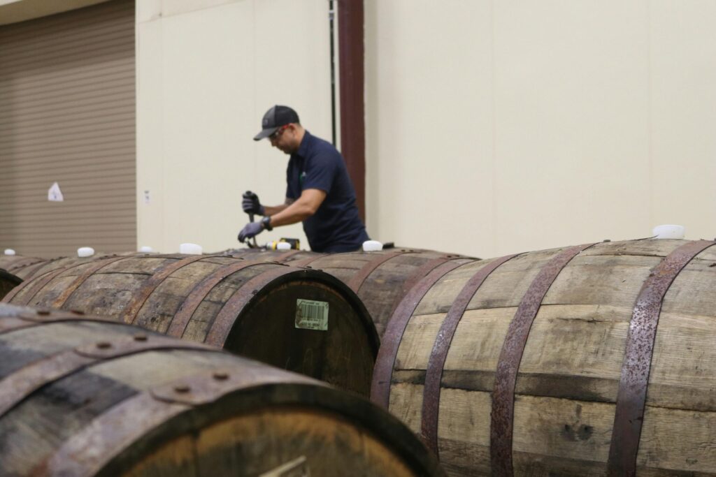 Image of a man opening a drum of bourbon in Kentucky